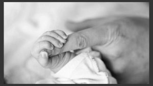 primer plano de mano de bebe agarrando fuerte el dedo de un adulto